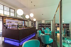 restauracja z niebieskimi krzesłami i barem w obiekcie Rome Life Hotel w Rzymie