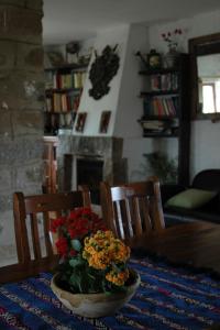 una mesa de comedor con un jarrón de flores. en Casa Rural Cortijo del Zoco Bajo en Pozoblanco