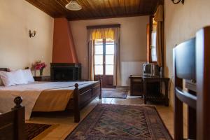 a bedroom with a bed and a tv and a window at Kadi in Tsepelovo