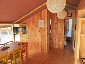 een eetkamer met houten wanden en een houten tafel bij Drago Tours LODGE TENT, Valkanela in Vrsar