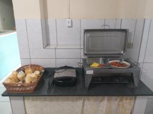 a kitchen counter with a microwave and a bowl of food at Hotel Casa Grande Max in Marília