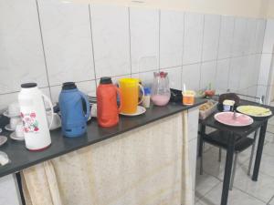 a kitchen counter with many different colored bottles on it at Hotel Casa Grande Max in Marília