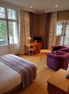 a bedroom with a bed and a chair and a desk at Hotel La Ferronniere in Bouillon