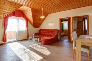 uma sala de estar com um sofá vermelho e uma mesa em Andrea Villa Hévíz I Balaton em Hévíz