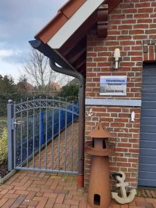 un bâtiment en briques avec un portail et une maison pour les oiseaux dans l'établissement Ferienwohnung Zum Lotsen, 45227, à Jemgum