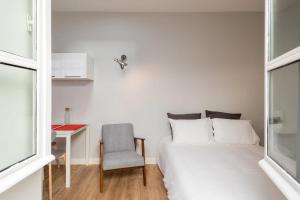 1 dormitorio con cama, silla y escritorio en DIFY Jaboulay - Jean Macé, en Lyon