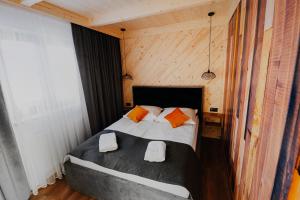 a bedroom with a bed with two towels on it at Apartamenty Oliwia in Małe Ciche