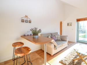 a living room with a couch and a table and chairs at Well View Cottage in Tarporley