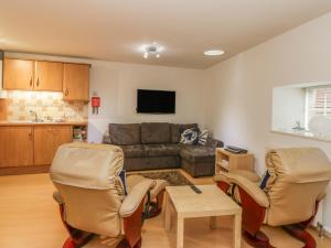 a living room with a couch and two chairs at Hayloft in Pittenweem