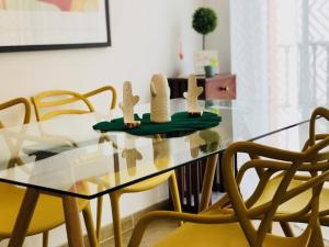 a glass dining room table with yellow chairs at Jimena in Fuengirola
