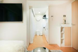 um quarto com uma cama e uma televisão na parede em P OIN T - Shinjuku Kabukicho Designer's Apartment I em Tóquio