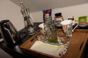 a wooden cutting board with glasses and bottles on a counter at Albatross B&B Dornoch in Dornoch