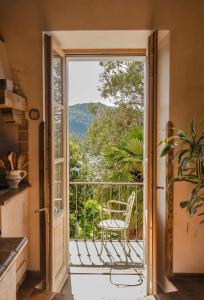 Drzwi na balkon z krzesłem w obiekcie Castellino Bella Vista w mieście Ponte Tresa