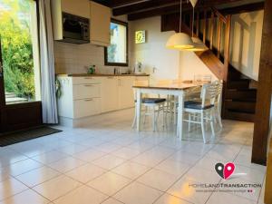 a kitchen and dining room with a table and chairs at OCELANDES 86 in Saint-Julien-en-Born