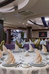une salle à manger avec une table et des assiettes de nourriture dans l'établissement Hotel Duman, à Astana