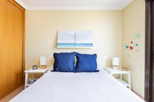 Un dormitorio con una cama grande con almohadas azules. en Home2Book La Tejita Beach and Pool, en Granadilla de Abona 30 fotos más