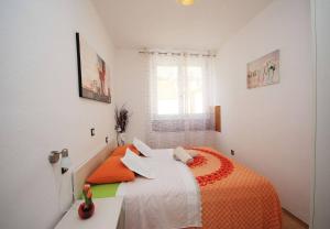 a bedroom with a bed with an orange blanket at Apartment JoviZ - 20m from the sea in Makarska