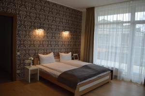a bedroom with a bed and a large window at Black Pearl Apartments in Jūrmala