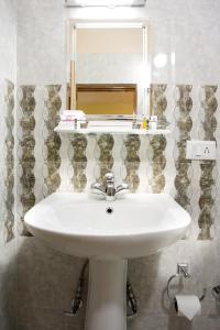 un bagno con un lavandino bianco e uno specchio di Golden Kuensel Resort & Spa a Kalimpong