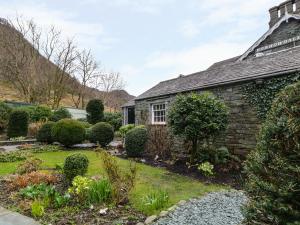 an old house with a garden in front of it at Coombe Cottage in Borrowdale Valley