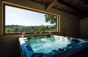 a large tub in a room with a large window at Agriturismo Casale San Lorenzo in San Lorenzo in Campo