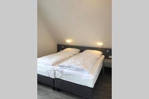 2 camas en una habitación con sábanas blancas en Ferienwohnung Nr. 2 - Düne en Werdum