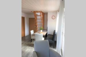 sala de estar con mesa, sillas y reloj en Ferienwohnung Nr. 2 - Düne en Werdum