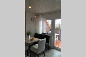comedor con mesa, sillas y ventana en Ferienwohnung Nr. 2 - Düne en Werdum