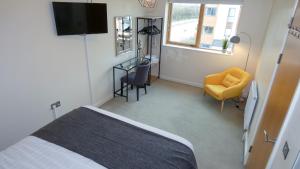 um quarto com uma cama, uma cadeira e uma secretária em Telford Townhouse with Parking em Telford