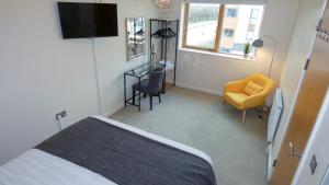 a bedroom with a bed and a chair and a desk at Telford Townhouse with Parking in Telford