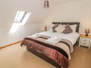 a bedroom with a bed with two towels on it at The Dairy in Newton Stewart