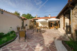 un patio extérieur avec des chaises, des tables et des parasols dans l'établissement Posada Condado de la Mota, à Mogro