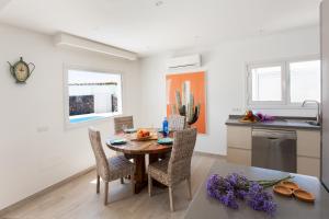a kitchen and dining room with a table and chairs at 3 bedroom Villa Delphi with private heated pool. in Puerto del Carmen