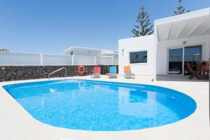 a swimming pool in front of a villa at 3 bedroom Villa Delphi with private heated pool. in Puerto del Carmen