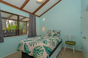 - une chambre avec un lit et une fenêtre dans l'établissement Bluebird Bach - Onemana Holiday Home, à Opoutere