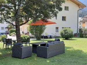 萊爾莫斯的住宿－Beim Franz，院子里的桌子和椅子以及雨伞
