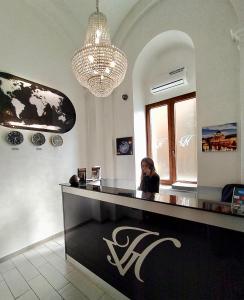 a woman talking on a cell phone at a counter at Al Viminale Hill Inn & Hotel in Rome