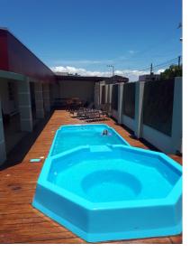 a large blue swimming pool on a deck at Pousada Espindola in Penha