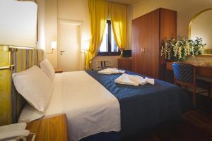 a hotel room with a bed with towels on it at Hotel Posta in Cecina
