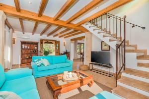 a living room with a blue couch and a table at Villa Font Xica Petit by Sealand Villas in El Port