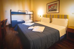 a hotel room with a bed with two towels on it at Hotel Posta in Cecina