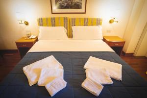 a bedroom with a bed with two pillows on it at Hotel Posta in Cecina