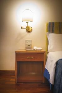 a lamp on a nightstand next to a bed at Hotel Posta in Cecina