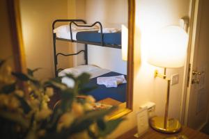 a room with two bunk beds and a mirror at Hotel Posta in Cecina