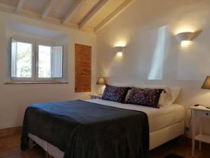 a bedroom with a bed and two windows at Amor de Crianca in São Teotónio