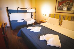 a room with two beds and a bunk bed at Hotel Posta in Cecina