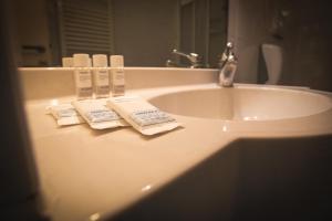 a bathroom sink with two towels and a mirror at Hotel Posta in Cecina