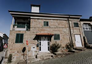 a stone building with a white door on a street at Casa da Calçada in Guimarães