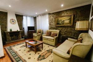 a living room with two couches and a table at Casa da Calçada in Guimarães