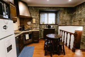 a kitchen with a table and stools in it at Casa da Calçada in Guimarães